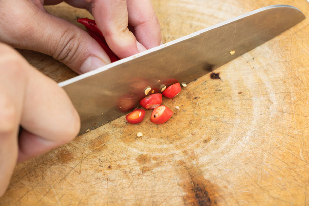 I peperoni rossi affettati su un tagliere di legno
 - Foto, immagini