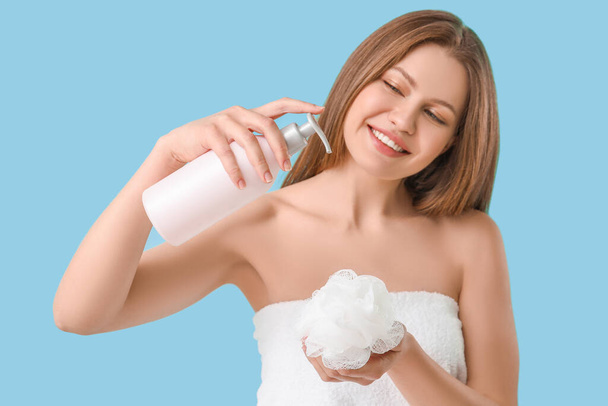 Krásná mladá žena se sprchovým gel na barevném pozadí - Fotografie, Obrázek