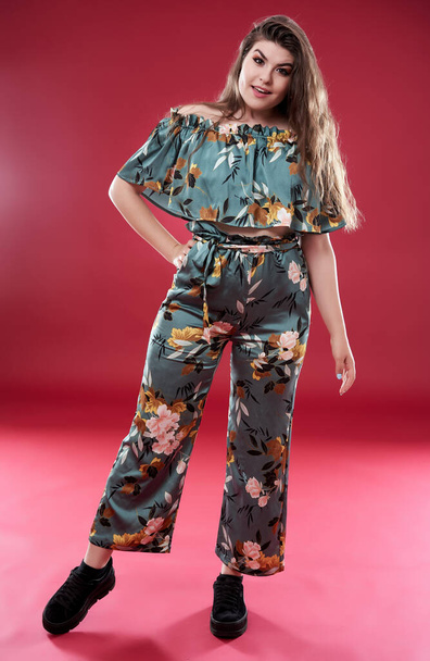 Young woman in floral clothing on red background - Foto, Bild