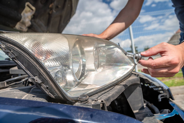 reparação do farol do carro, substituindo lâmpadas ruins com novos
 - Foto, Imagem