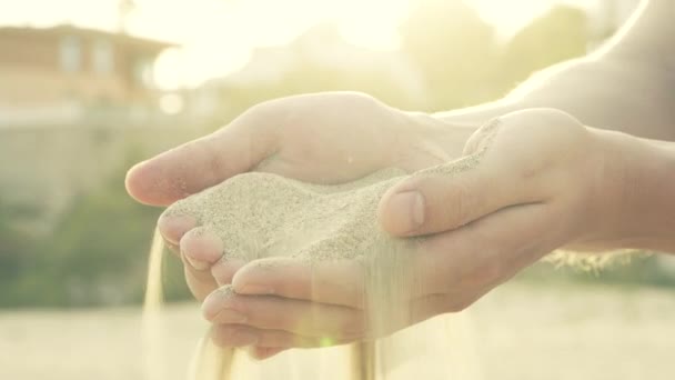 Sabbia disseminata attraverso le mani delle dita
 - Filmati, video