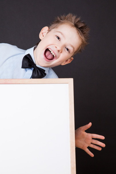 Portrait of cheerful boy pointing on white banner - Foto, afbeelding
