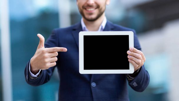 Businessman pointing at empty tablet screen on city street, close up. Mockup for design - Foto, Imagen