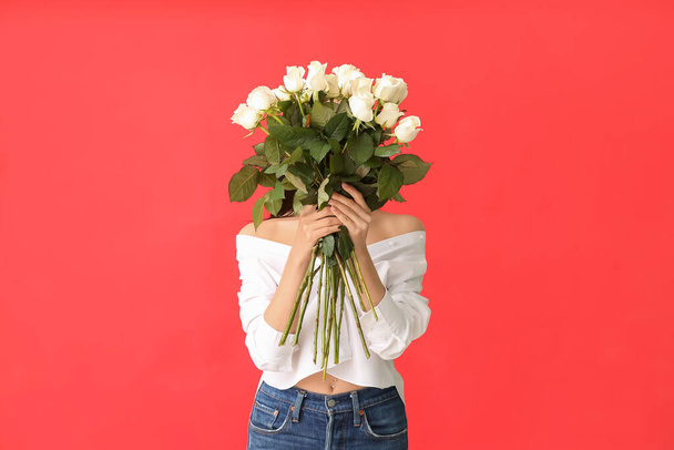 Beautiful young woman with bouquet of roses on color background - 写真・画像