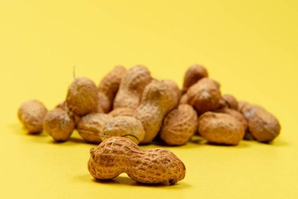 shelled peanuts on yellow background, front view - 写真・画像
