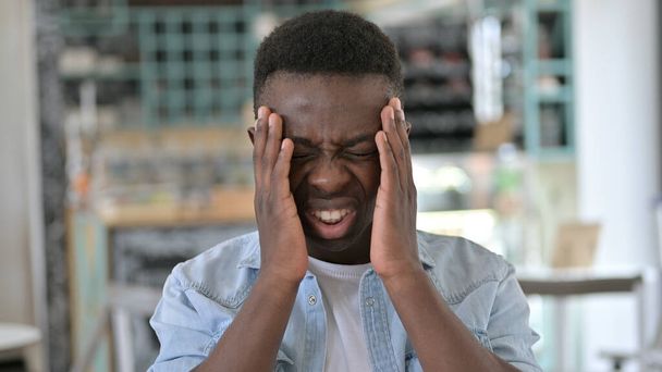Muotokuva stressaantunut nuori afrikkalainen mies, jolla on päänsärky
 - Valokuva, kuva