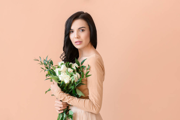 Beautiful young woman with bouquet of roses on color background - Foto, Imagem