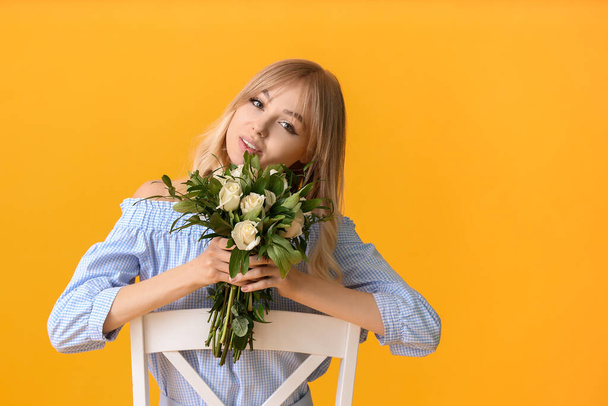 Gyönyörű fiatal nő csokor rózsa a színes háttér - Fotó, kép