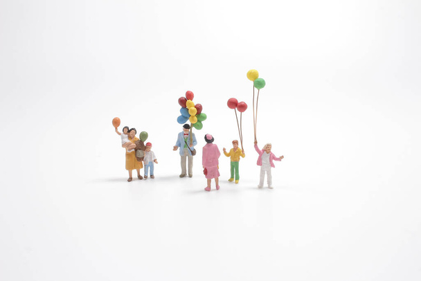 счастливая семья держит воздушные шары с белым фоном в качестве счастливой концепции семьи
. - Фото, изображение