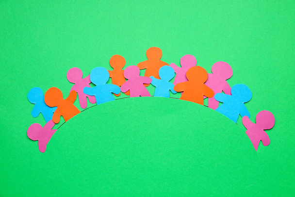 Kağıt insan figürleri renk arka planında el ele tutuşuyorlar. Birlik kavramı - Fotoğraf, Görsel