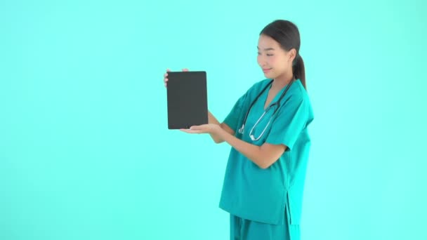 felvétel gyönyörű ázsiai női orvos gazdaság digitális tabletta üres képernyő kék - Felvétel, videó