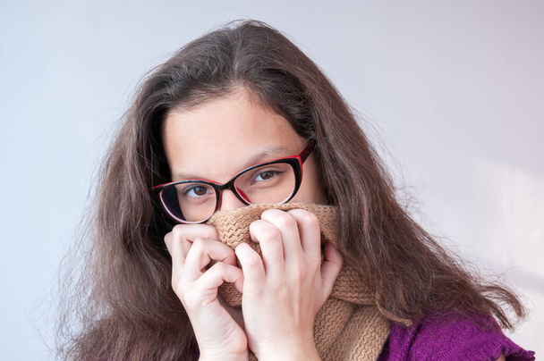 Girl with glasses covers mouth with a scarf - Φωτογραφία, εικόνα