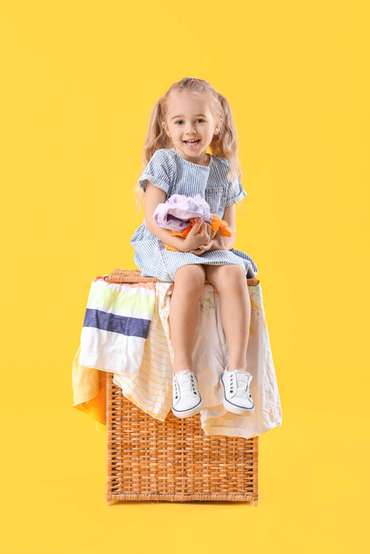 Linda niña con ropa sucia en el fondo de color
 - Foto, imagen