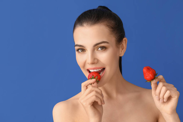 Sexy young woman with strawberry on color background - Φωτογραφία, εικόνα