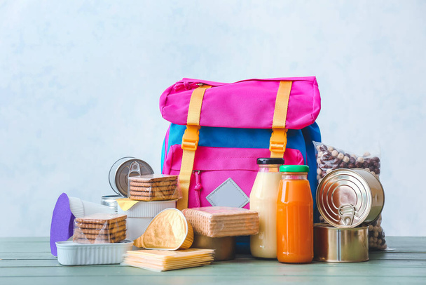 Schoolbag με διαφορετικά προϊόντα στο τραπέζι. Έννοια του προγράμματος τροφίμων σακίδιο - Φωτογραφία, εικόνα