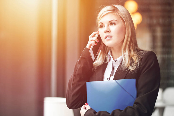 Business woman talking on the phone. Portrait of beautiful girl in office - 写真・画像