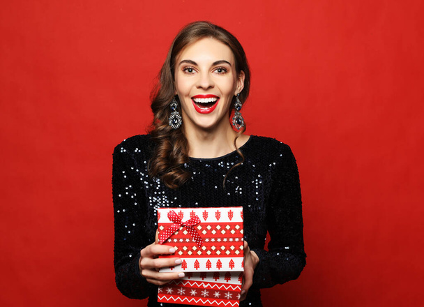 lifestyle, people and holiday concept: young woman in evening dress holding opened present box - Foto, imagen