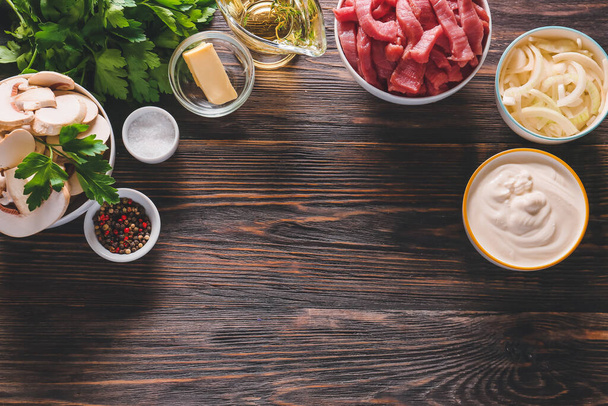 Ingrediënten voor rundvlees stroganoff met champignons op tafel - Foto, afbeelding