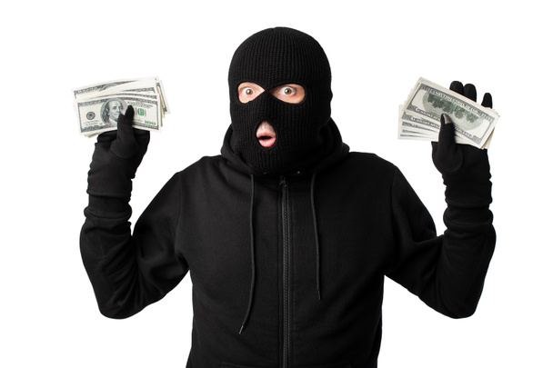 Arrested masked thief with raised arms isolated on white wall - 写真・画像