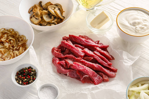 Ingrediënten voor rundvlees stroganoff met champignons op tafel - Foto, afbeelding