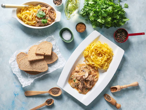 Plate with tasty beef stroganoff and pasta on color background - Photo, Image