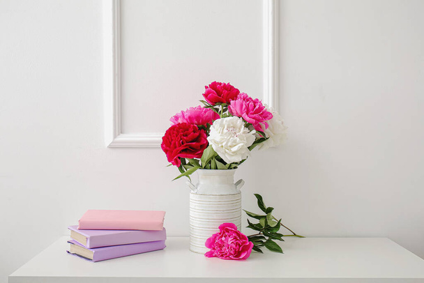 美しい牡丹の花や本が部屋のテーブルの上に花瓶 - 写真・画像