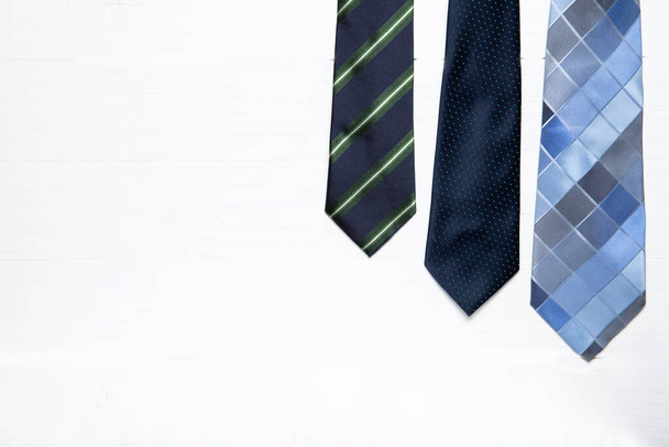 Ανδρικές γραβάτες σε λευκό ξύλινο φόντο. Θέση για κείμενο - Φωτογραφία, εικόνα