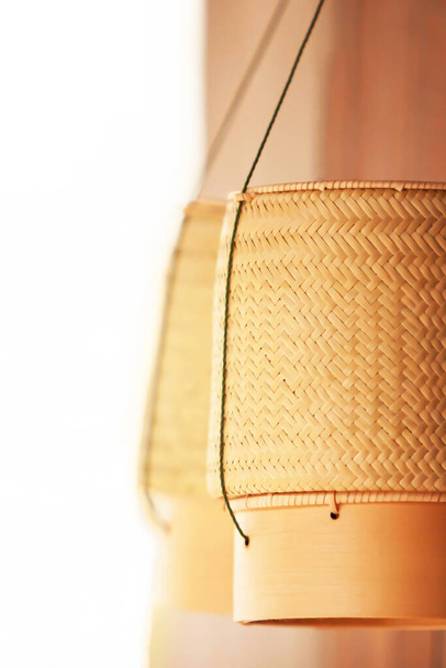 Dos cestas de arroz pegajosas colgando de un pilar de madera, producto de bambú artesanal en el noreste de Tailandia. Enfoque selectivo. Fondo blanco con espacio de copia
. - Foto, imagen