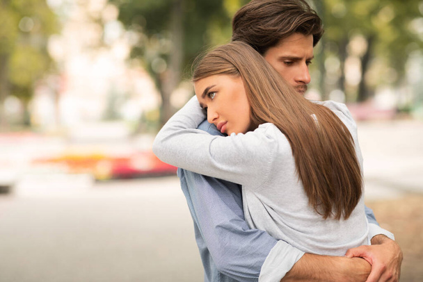 Θλιμμένος άντρας και κορίτσι αγκαλιάζονται νιώθοντας ότι δεν αγαπιούνται. - Φωτογραφία, εικόνα
