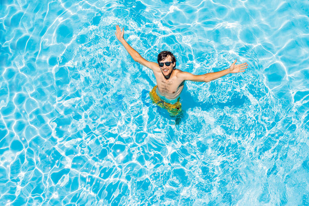 Young man swims in the pool, summer vacation concept - Foto, imagen