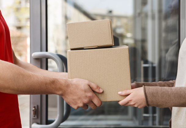 Guaranteed excellent service. Hands of client and courier are holding parcels - Foto, Imagen