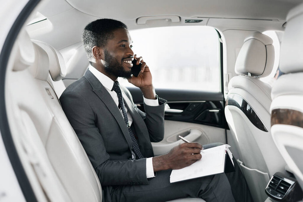 Empresário Africano alegre conversando no telefone Trabalhando sentado no carro
 - Foto, Imagem
