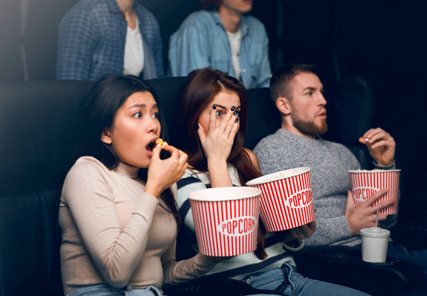 Young people scared of horror movie in film theater - Foto, Imagem