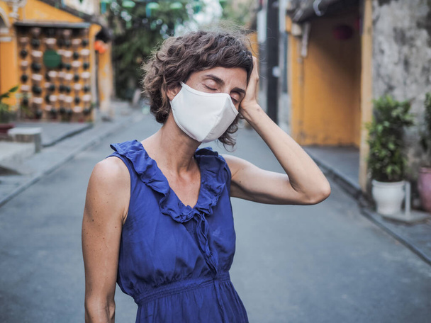 woman wearing protective mask and blue dress, coronavirus pandemic and quarantine concept - 写真・画像