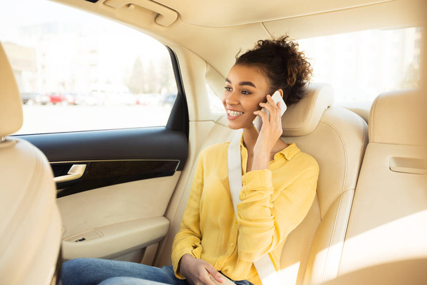 Usmívající se černošky žena mluví na telefonu sedí v taxi taxíku - Fotografie, Obrázek