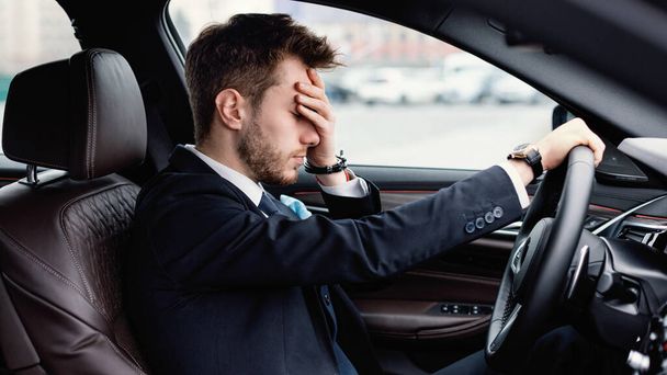 彼の新しい車で一人で運転するストレスのあるビジネスマン - 写真・画像