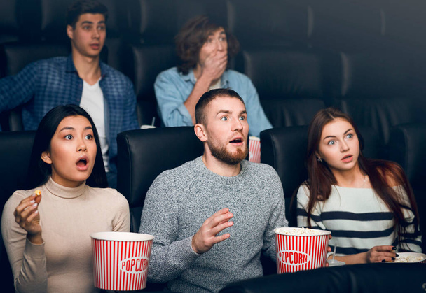 Налякані молоді люди дивляться нове кіно в кінотеатрі
 - Фото, зображення