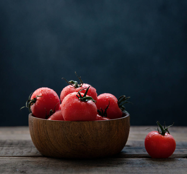fresh  cherry red tomatoes in a wooden bowl on a wooden old table. Frontal and macro view - Fotografie, Obrázek