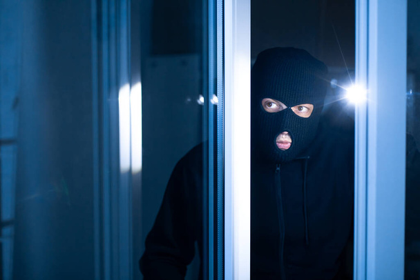 Burglar breaking in an apartment or office to steal something - Photo, Image