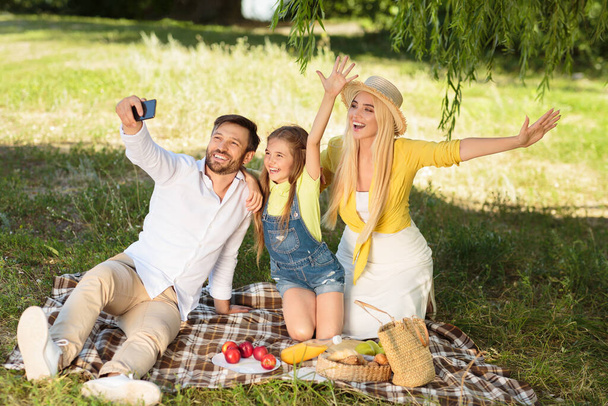 gelukkig familie op picknick maken selfie besteden dag samen buiten - Foto, afbeelding