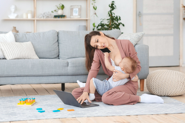 Stress tijdens het zwangerschapsverlof. Moeder werken thuis en borstvoeding zuigeling baby - Foto, afbeelding