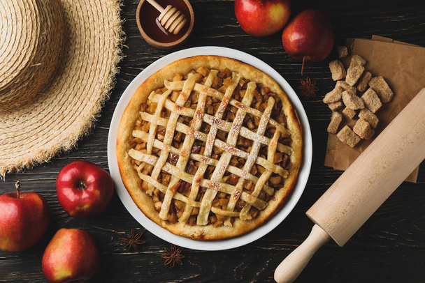 Композиція з яблучним пирогом та інгредієнтами на дерев'яному фоні. Саморобна їжа
 - Фото, зображення
