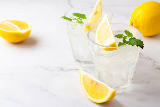 drank met ijs citroen in glazen op een witte achtergrond - Foto, afbeelding