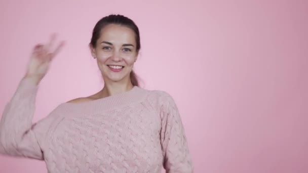 Happy woman in knitted pink sweater funny dancing isolated on pink background - 映像、動画