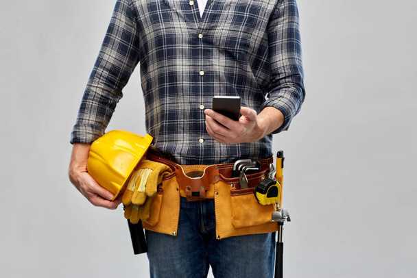 worker or builder with phone and working tools - Fotoğraf, Görsel