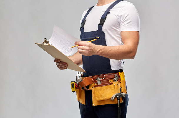 builder with clipboard, pencil and working tools - Φωτογραφία, εικόνα