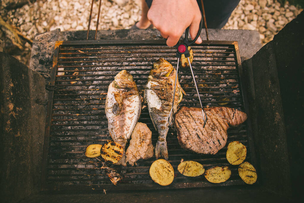 cocinar pescado y patatas a la parrilla al aire libre - Foto, Imagen