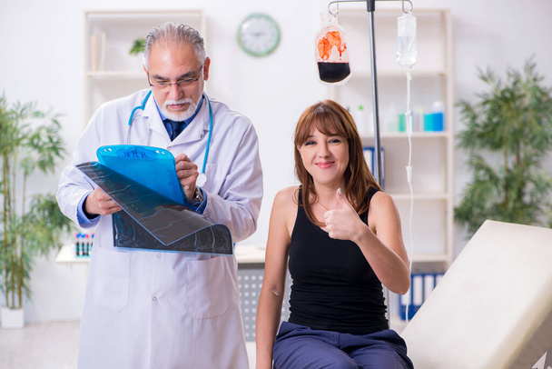 Young woman visiting old male doctor - Photo, image