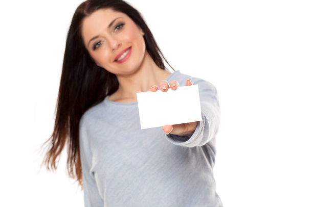Lächelnde Frau zeigt leeres leeres Papierkartenschild mit Kopierplatz für Text - Foto, Bild