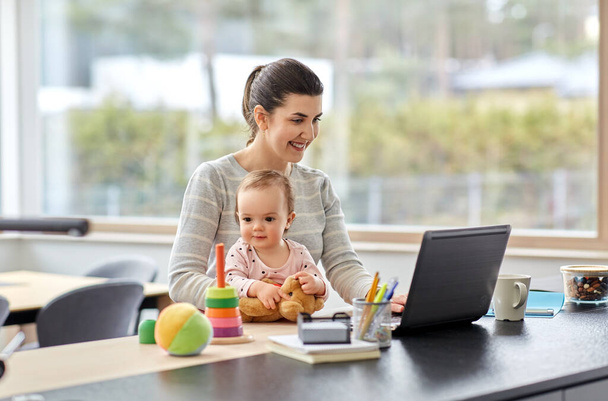 mother with baby and laptop working at home office - Foto, imagen